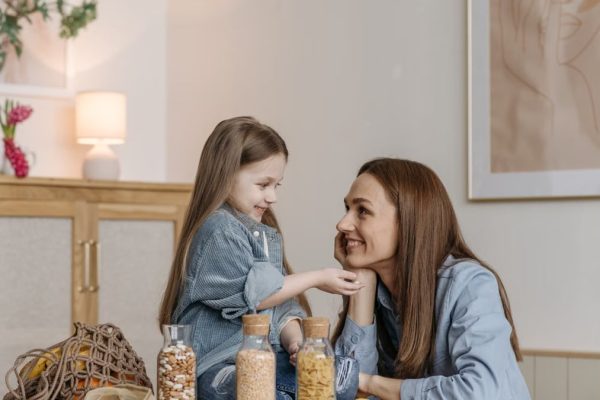 A loving mother and daughter enjoying quality time together in a cozy kitchen setting.